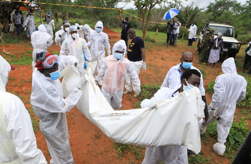  Forensic experts and homicide detectives carry the bodies of suspected members of a Christian cult named as Good News International Church, who believed they would go to heaven if they starved themselves to death, after their remains were exhumed from their graves in Shakahola forest of Kilifi coun (photo credit: STRINGER/ REUTERS)