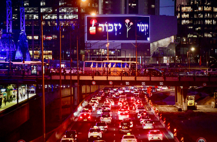 People stand as one minute siren sounded across Israel, marking Remembrance Day on Ayalon highway, Tel Aviv, April 24, 2023. (credit: AVSHALOM SASSONI/FLASH90)