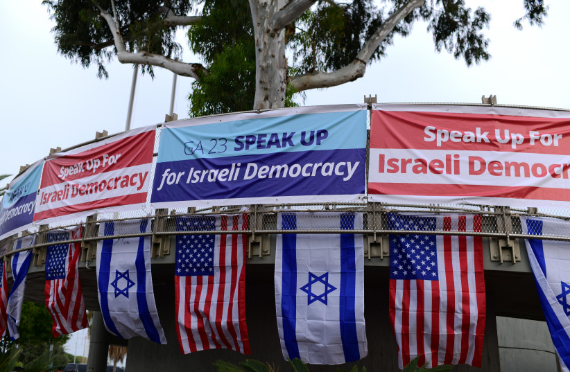  Israelis holding the US and Israeli flag protest outside the Jewish Federation of North America (JFNA) conference, in Tel Aviv, on April 23, 2023. (photo credit: TOMER NEUBERG/FLASH90)