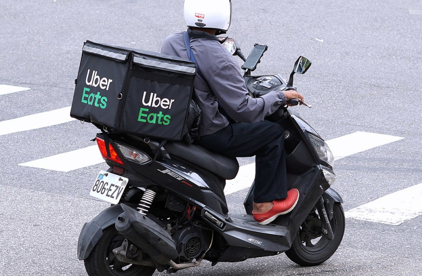  A driver is seen making an Uber Eats delivery (Illustrative). (photo credit: Wikimedia Commons)