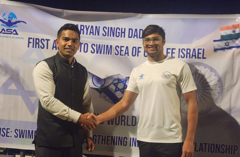  INDIAN DIPLOMAT Pawan Kumar (left) congratulates Indian swimmer Aryan Singh Dadiala on his record-breaking swim across Lake Kinneret. (credit: COURTESY INDIAN EMBASSY IN ISRAEL)
