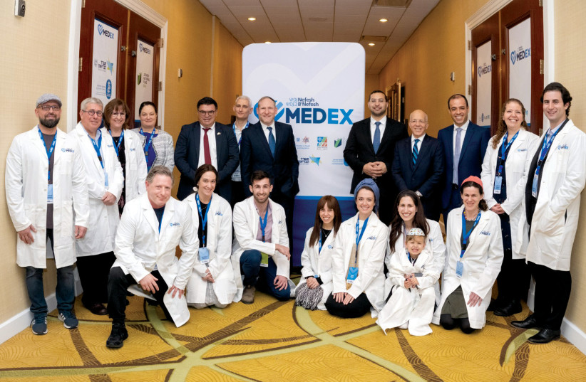  (Standing, fourth from left) Neta Katz Epstein; MK Michael Biton; Dr. Sefi Mendelovich; Rabbi Yehoshua Fass; Yitzhak Wasserlauf; Tony Gelbart; Avichai Kahana, surrounded by medical professionals at MedEx. (photo credit: NEFESH B'NEFESH)