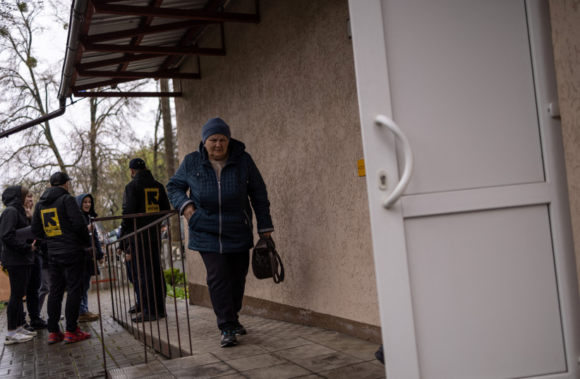 A local resident arrives to see a doctor at a clinic in the liberated village of Vyshneva, near Kharkiv, in eastern Ukraine, April 21, 2023. (photo credit: Carlos Barria/Reuters)