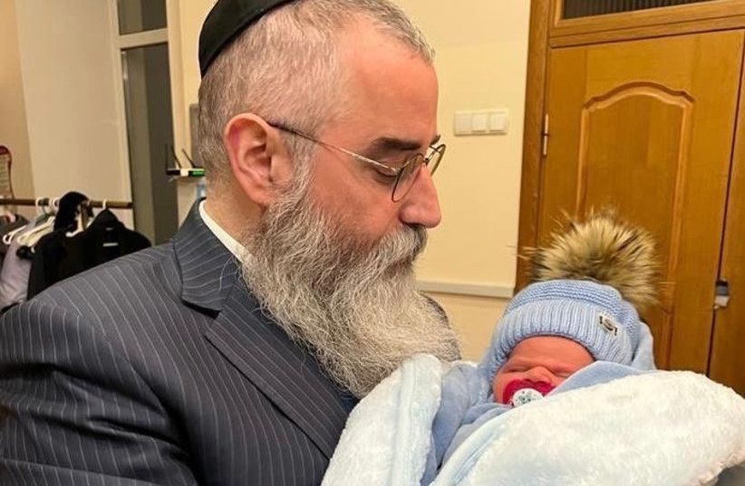Rabbi Wollf hold a newbrn who recently welcome in the orphanage.