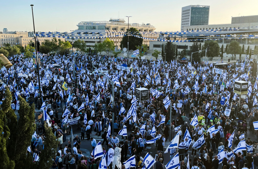  Right-wing demonstrators hold Israeli flags at a protest calling on the Israeli government to complete its planned judicial overhaul, in front of the Knesset, Israel's Parliament, in Jerusalem, April 27, 2023.  (credit: REUTERS/ILAN ROSENBERG)