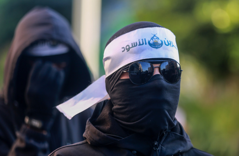 Palestinians Hamas militants wearing headbands reading ''the Lion's Den'', during a march in support of the group in Gaza City on December 10, 2022. (credit: ATIA MOHAMMED/FLASH90)