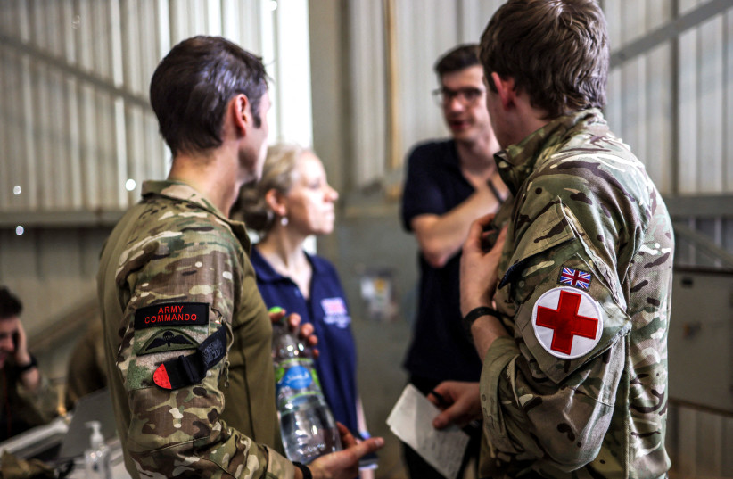  FCDO personnel talks with an Army Commando Medic and a member of the Medical Emergency Response Team during the evacuation of British citizens, at Wadi Seidna airport, Sudan April 27, 2023 (credit: Arron Hoare/UK MOD/Handout via REUTERS)