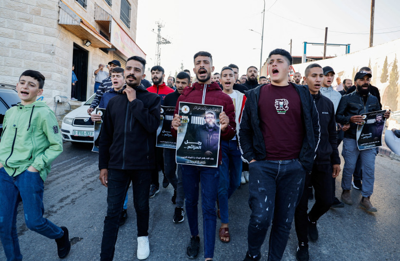  Palestinians rally holding posters following the death of Palestinian prisoner Khader Adnan during a hunger strike in an Israeli jail, near Jenin in the West Bank, May 2, 2023. (photo credit: REUTERS/RANEEN SAWAFTA)