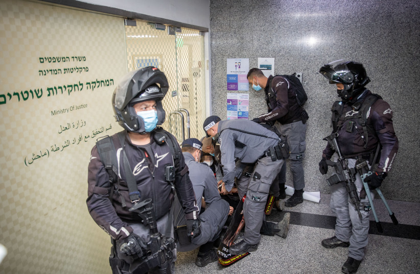 Police arrest a demonstrator during a protest outside Machash, the Police Internal Investigations Department, in Jerusalem on February 9, 2021. (credit: YONATAN SINDEL/FLASH90)