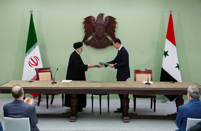  Syria's President Bashar al-Assad and Iranian President Ebrahim Raisi are pictured during the signing of cooperation agreement in Damascus, Syria, in this handout released by SANA on May 3, 2023 (photo credit: SANA/HANDOUT VIA REUTERS)