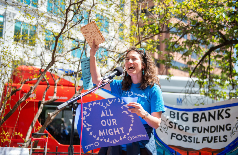  Rabbi Laura Bellows, now Dayenu's director of spiritual activism and education, waves matzah as she encourages major financial organizations to divest from fossil fuels at a rally in Washington, DC, April 20, 2022. (credit: Bora Chung | Survival Media Agency/Courtesy of Dayenu)