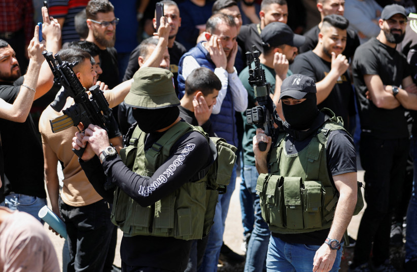  Mourners react as a militant fires a weapon in the air during the funeral of Palestinian gunmen who were killed by Israeli forces in a raid, in Nablus West Bank May 4, 2023 (photo credit: REUTERS/RANEEN SAWAFTA)