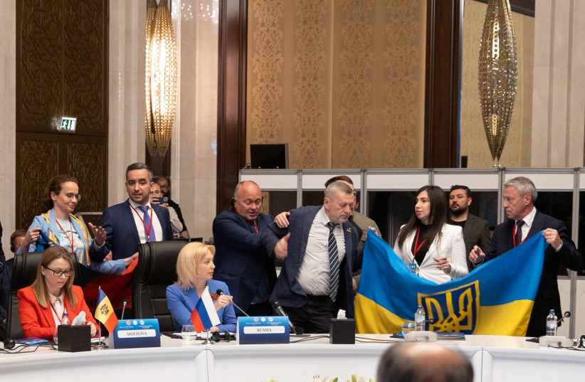  Members of Ukrainian delegation unfurl their national flag next to Olga Timofeeva, deputy head of Russian delegation, to disrupt her speech during a meeting of the Parliamentary Assembly of the Black Sea Economic Cooperation (PABSEC) in Ankara, Turkey May 4, 2023. (photo credit:  Edib Kurt/Turkish Grand National Assembly, TBMM/Handout via REUTERS)
