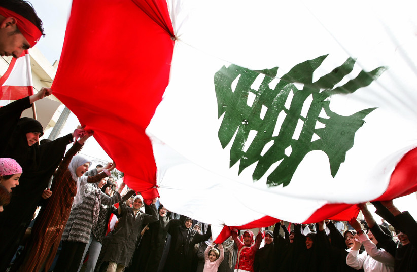 Lebanese anti-US protesters wave a big Lebanese flag during a protest in front of the US embassy near Beirut, April 1, 2005 (credit: REUTERS/DAMIR SAGOLJ/FILE PHOTO)
