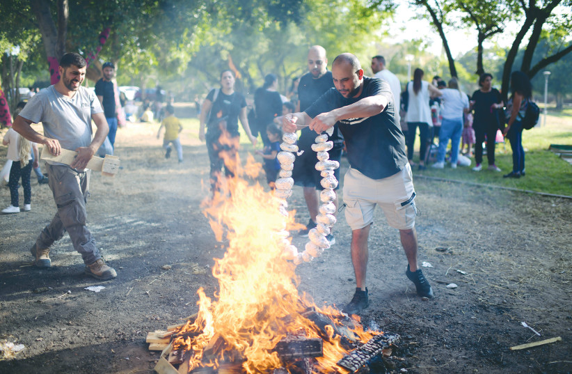  CHILDREN AND their parents gather around a bonfire to celebrate Lag Ba’omer last year, in Tel Aviv. ‘We thought it was time to resurrect the holiday and make it relevant for our community,’ says the writer.  (photo credit: TOMER NEUBERG/FLASH90)