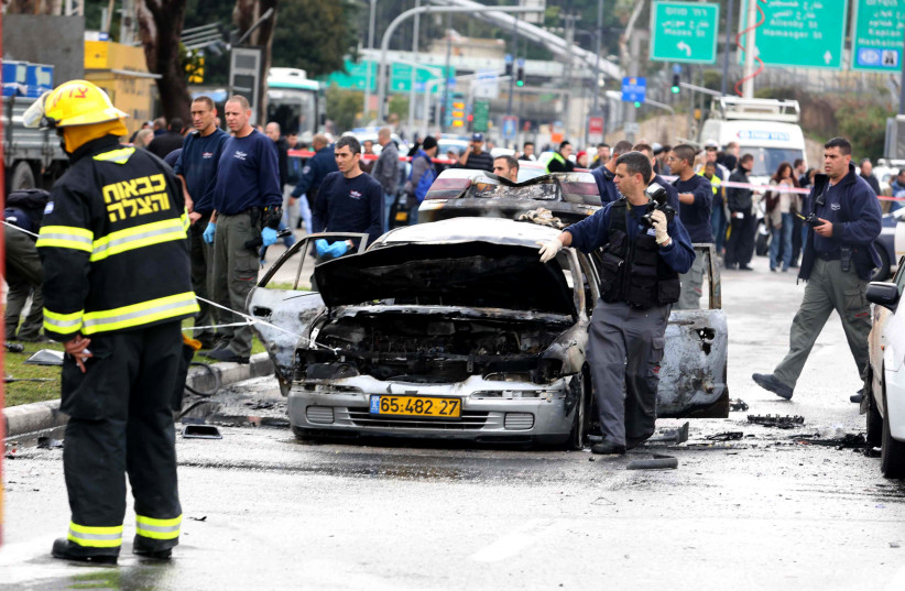  Investigators work near a damaged cars after it exploded near the Israeli defence ministry injuring several people in Tel Aviv on January 10, 2013. (credit: FLASH90)