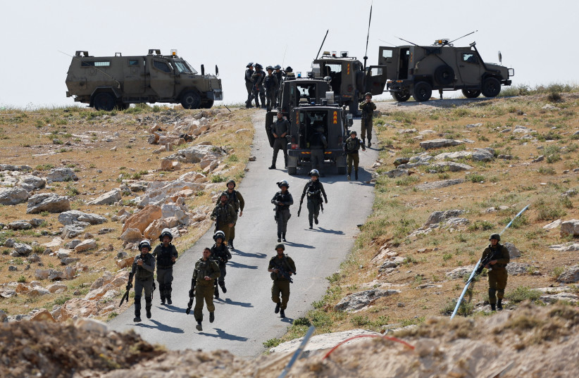 Israeli troops take position during clashes between Palestinians and Israeli troops after Israeli machinery demolish a school near Bethlehem in the West Bank May 7, 2023 (credit: REUTERS/MUSSA QAWASMA)
