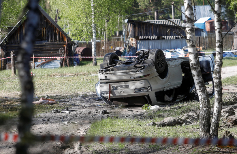 A view shows a damaged white Audi Q7 car lying overturned on a track next to a wood, after Russian nationalist writer Zakhar Prilepin was allegedly wounded in a bomb attack in a village in the Nizhny Novgorod region, Russia, May 6, 2023. (photo credit: REUTERS/Anastasia Makarycheva)