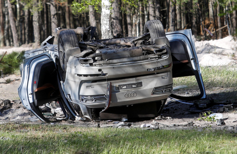 A view shows a damaged white Audi Q7 car lying overturned on a track next to a wood, after Russian nationalist writer Zakhar Prilepin was allegedly wounded in a bomb attack in a village in the Nizhny Novgorod region, Russia, May 6, 2023 (credit: REUTERS/Anastasia Makarycheva)