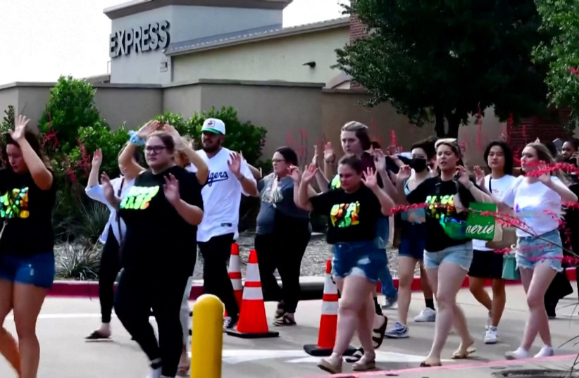  Shoppers leave with their hands up after police responded to a gunman who shot and killed eight people and wounded at least seven others at Allen Premium Outlets mall north of Dallas, in Allen, Texas, US May 6, 2023 in a still image from video. (credit: REUTERS/Reuters TV)
