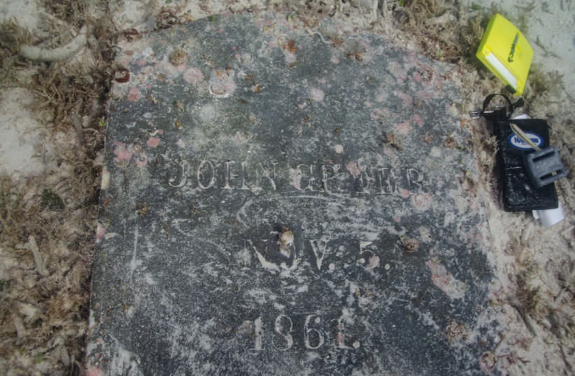 The headstone of John Greer was found underwater by archeologists during a survey at Dry Tortugas National Park. The inscription reads "John Greer. Nov. 5. 1861." (photo credit: Image courtesy of the National Park Service)