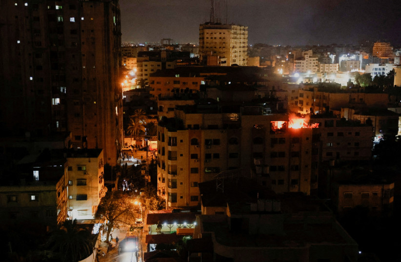 A fire burns in a building after the Israeli military struck Islamic Jihad targets, it said in a statement, in Gaza, May 9, 2023 (credit: MOHAMMED SALEM/REUTERS)