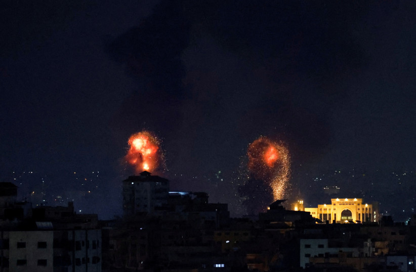 Explosions light up the sky after the Israeli military said in a statement that it has struck Islamic Jihad targets, in Gaza, May 9, 2023 (photo credit: MOHAMMED SALEM/REUTERS)