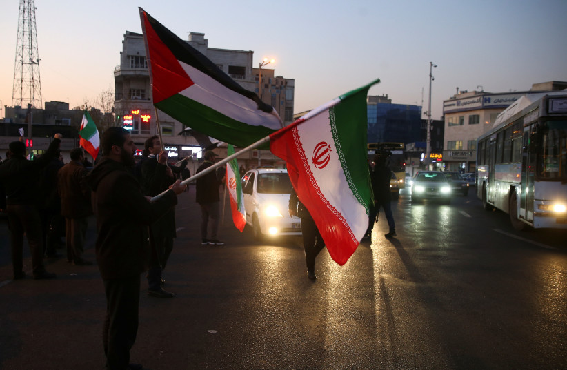  People hold a Palestinian and Iranian flags as they celebrate in the street after Iran launched missiles at U.S.-led forces in Iraq, in Tehran, Iran January 8, 2020.  (photo credit: NAZANIN TABATABAEE/WANA VIA REUTERS)
