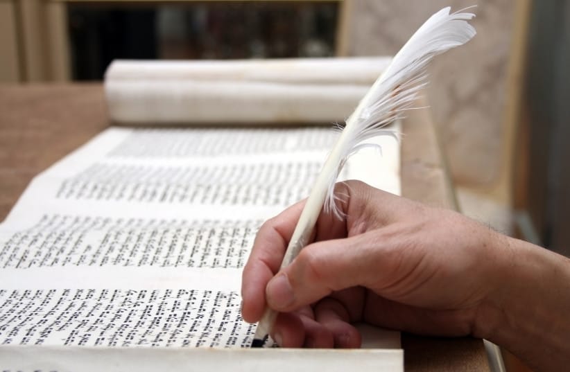 A Torah scroll being written.