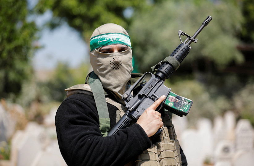  A person holds up a gun during the funeral of two Palestinian Islamic Jihad gunmen who were killed in an Israeli raid, in Jenin refugee camp in the West Bank May 10, 2023. (credit: RANEEN SAWAFTA/REUTERS)