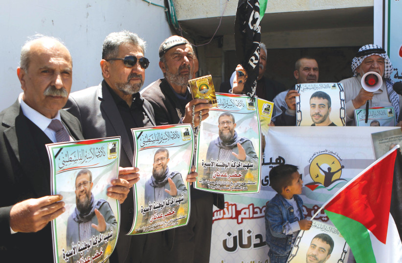  PALESTINIANS PROTEST outside the offices of the Red Cross in Hebron, last Thursday, following the death of hunger striker Khader Adnan (photo credit: WISAM HASHLAMOUN/FLASH90)