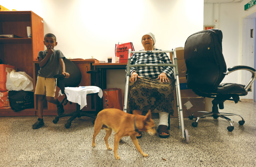  ASHKELON RESIDENTS wait in a bomb shelter with a pet dog as sirens wail during a rocket attack from Gaza on Wednesday. (photo credit: AMIR COHEN/REUTERS)