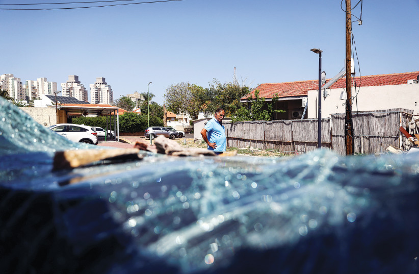  A VIEW through the broken windshield of a car shows the area outside a home that was damaged when a rocket, fired from Gaza, landed in Ashkelon, Wednesday.  (photo credit: RONEN ZVULUN/REUTERS)