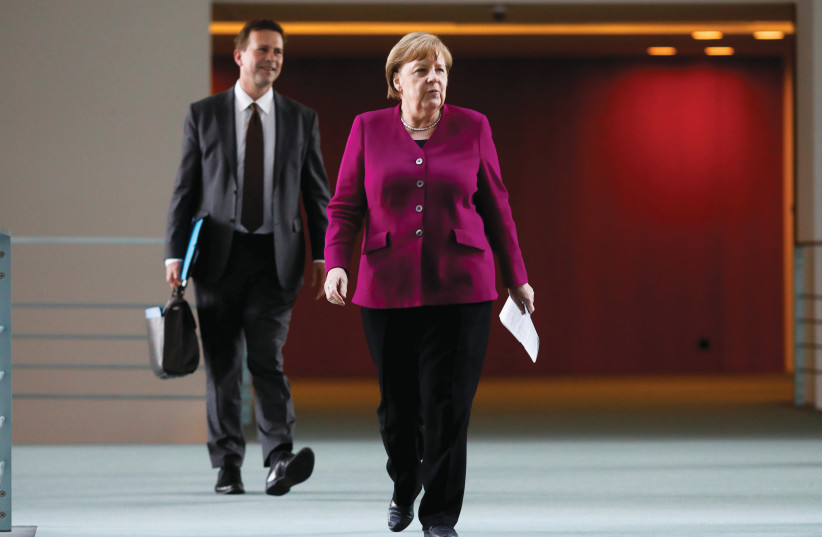  ANGELA MERKEL, then German chancellor, arrives with her spokesman Steffen Seibert for a news conference after a meeting with governors of former East German states at the Chancellery in Berlin, in 2020.  (photo credit: REUTERS)