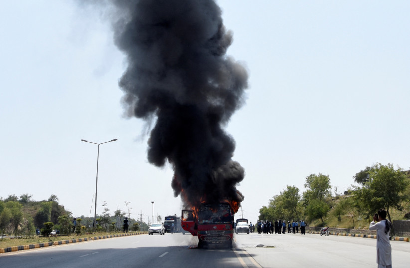  Fire and smoke billows from a bus after it caught a fire during clashes between police and supporters of Pakistan's former prime minister Imran Khan in Islamabad, Pakistan, May 12, 2023. (credit: STRINGER/ REUTERS)