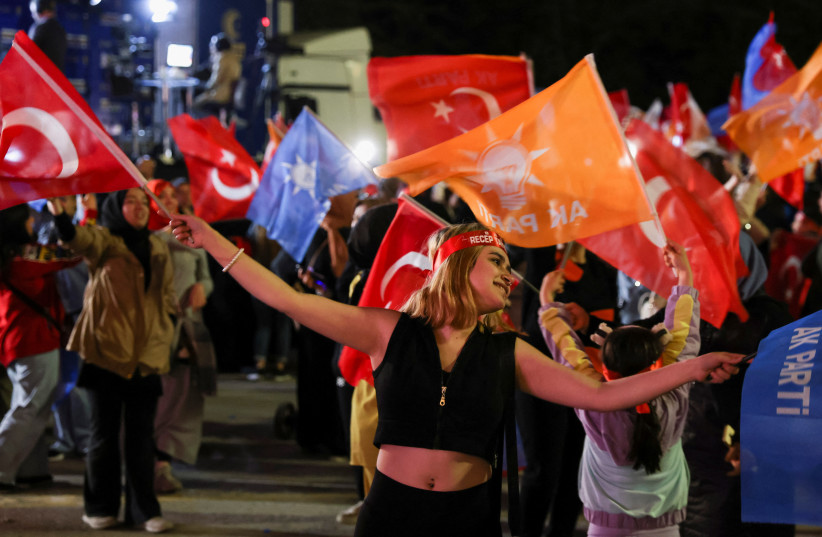  A supporter of Turkish President Tayyip Erdogan waves flags outside the AK Party headquarters, in Ankara, Turkey May 15, 2023 (photo credit: REUTERS)