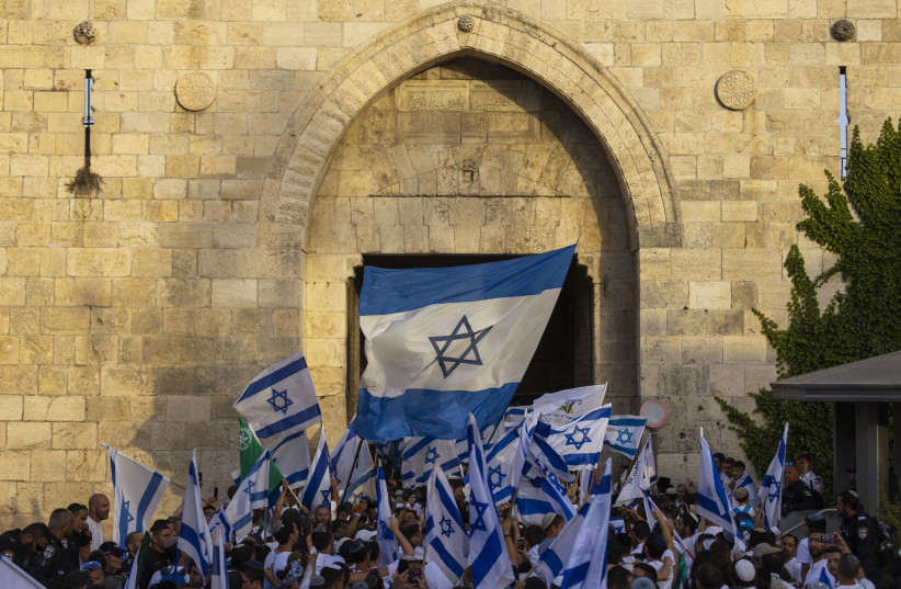  Young Jewish men holding Israeli flags as they dance at Damascus Gate in Jerusalem's Old City, during Jerusalem Day celebrations, May 29, 2022. (credit: OLIVIER FITOUSSI/FLASH90)