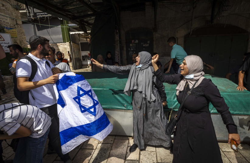  Young Jewish men holding the Israeli flag argue with Arabs as they march through the Muslim quarters of Jerusalem's Old City, during Jerusalem Day celebrations, May 29, 2022. (credit: OLIVIER FITOUSSI/FLASH90)