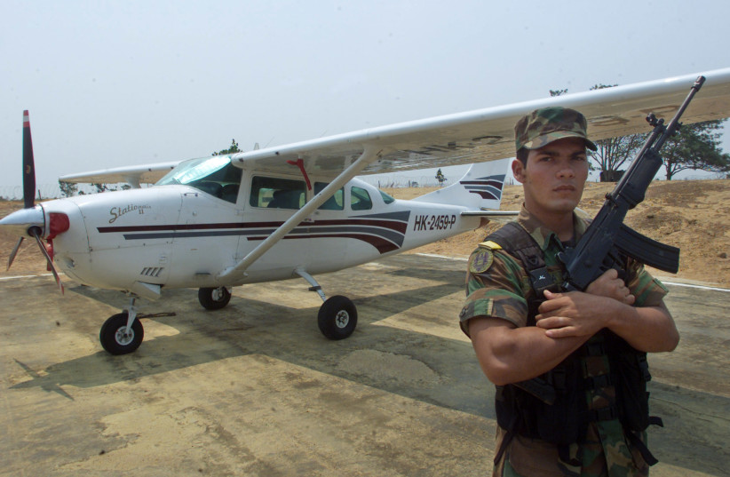  A Colombian soldier stands next to a Cessna 206 of alleged drug trafficker Luis Fernando da Costa, in Marandua army base, April 22, 2001. (credit: REUTERS)