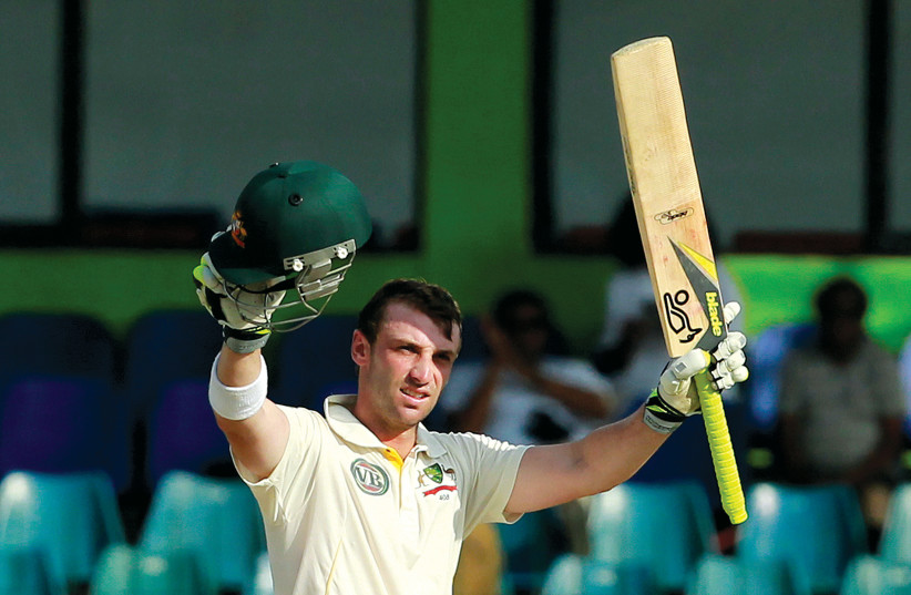  Phillip Hughes raises his bat after scoring a century (100 runs) during the team’s fourth day of their third and final cricket match against Sri Lanka in Colombo on September 19, 2011.  (photo credit: DINUKA LIYANAWATTE/REUTERS)