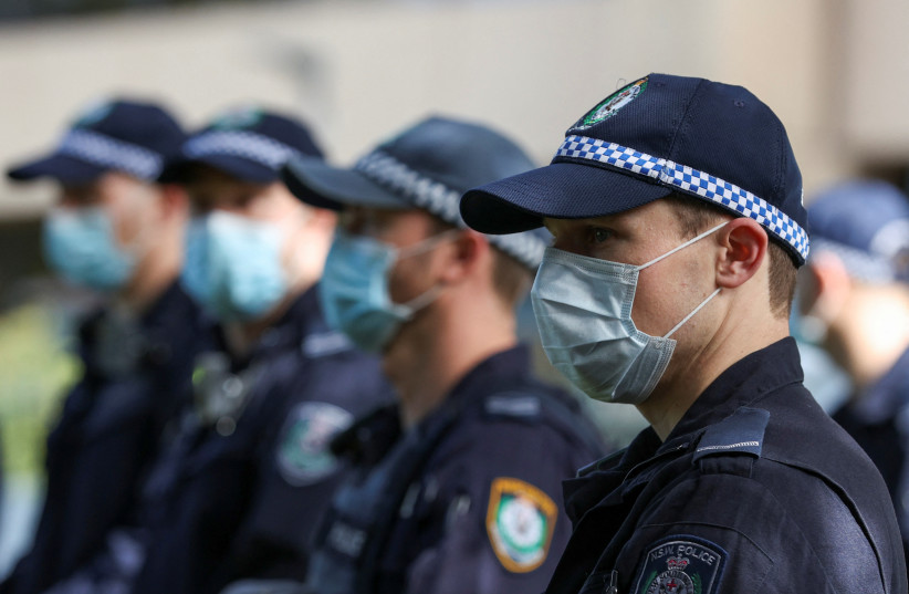  Police officers surround a police van as they issue citation tickets to demonstrators, after shutting down a rally that was deemed unlawful, in Sydney, Australia, July 28, 2020 (credit: REUTERS/LOREN ELLIOTT)