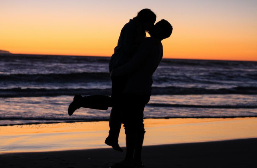  A young couple kissing at the beach during a sunset. (credit: FREERANGE STOCK)