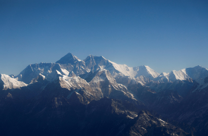 Mount Everest, the world highest peak, and other peaks of the Himalayan range are seen through an aircraft window during a mountain flight from Kathmandu, Nepal January 15, 2020. (photo credit: REUTERS/Monika Deupala//File Photo)