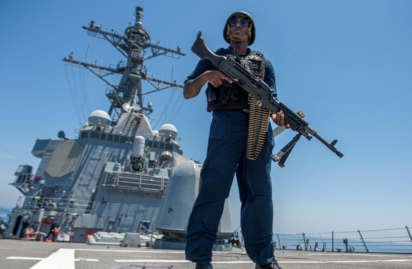 Master-At-Arms 1st Class Julius Earl stands watch with an M240B machine gun on the fo'c'scle of the guided-missile destroyer USS Paul Hamilton (DDG 60), deployed to the U.S. 5th Fleet area of operations to help ensure maritime security and stability in the Middle East region, during a Strait of Horm (photo credit: US NAVAL FORCES CENTRAL COMMAND/US 5TH FLEET/HANDOUT VIA REUTERS)