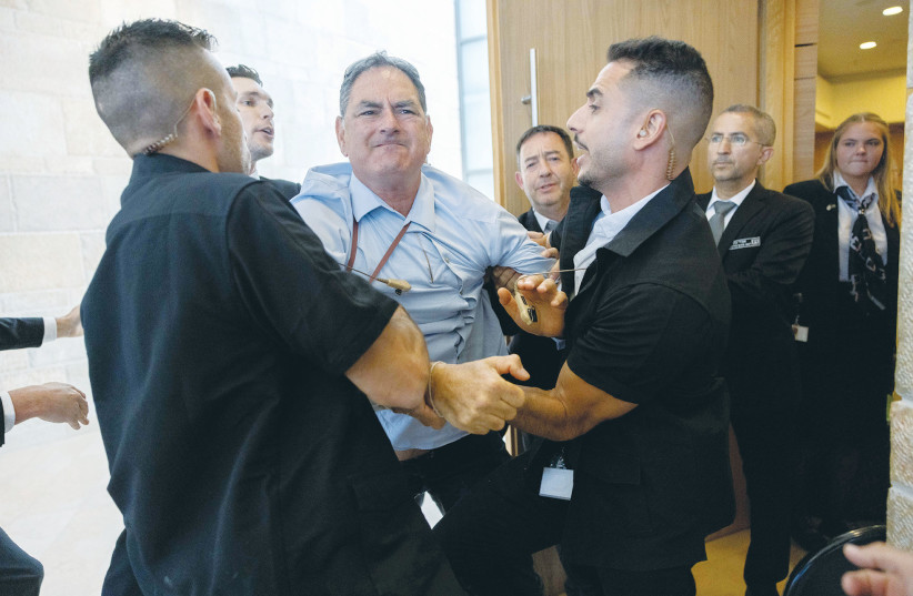  HIZKY SIVAK of the Emek Hefer Regional Council is removed by security personnel from a stormy meeting and vote at the Knesset Finance Committee on the Arnona Fund, last Monday. (credit: YONATAN SINDEL/FLASH90)