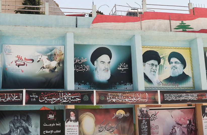  BANNERS DEPICT (left to right) Iran’s late leader Ayatollah Ruhollah Khomeini, current Supreme Leader Ayatollah Ali Khamenei and Hezbollah leader Hassan Nasrallah, in Yaroun, southern Lebanon.  (photo credit: REUTERS/ISSAM ABDALLAH)