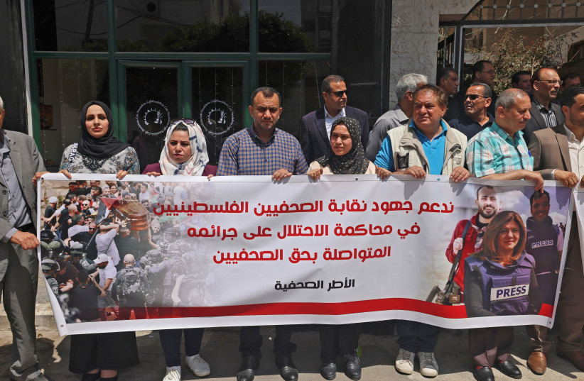  Members of the Palestinian Journalists Syndicate in Gaza take part in a protest in Gaza city on May 30, 2022, expressing support for efforts to prosecute Israel in international instances over the reported killing of journalists. (photo credit: MOHAMMED ABED/AFP/GETTY IMAGES)