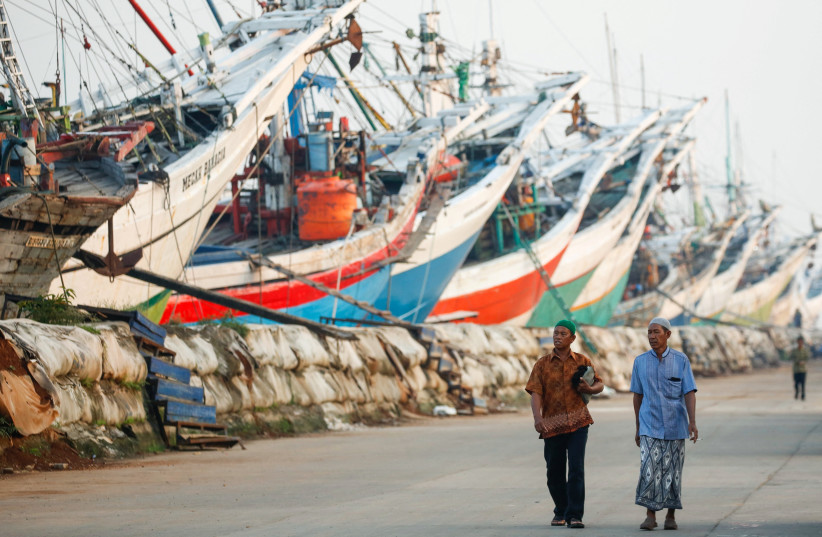  Muslim men walk to attend mass prayers at the Sunda Kelapa port during Eid al-Fitr, marking the end of the holy fasting month of Ramadan in Jakarta, Indonesia, April 22, 2023.  (photo credit: REUTERS/AJENG DINAR ULFIANA)