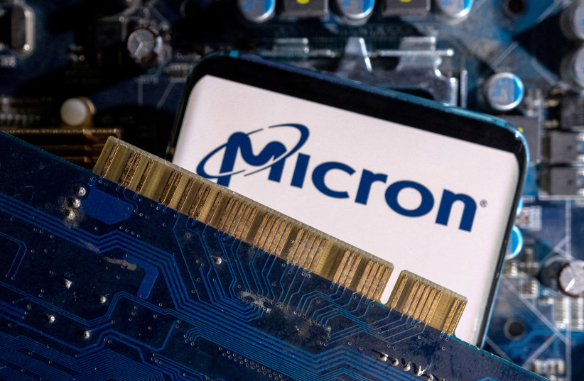  A smartphone with a displayed Micron logo is placed on a computer motherboard in this illustration taken March 6, 2023 (photo credit: REUTERS)