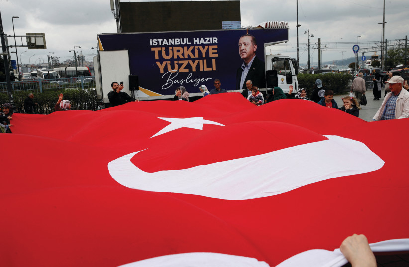  SUPPORTERS OF Turkish President Recep Tayyip Erdogan unfurl a large Turkish flag at an election campaign point in Istanbul, this past weekend, ahead of next Sunday’s runoff vote. (photo credit: DILARA SENKAYA/REUTERS)